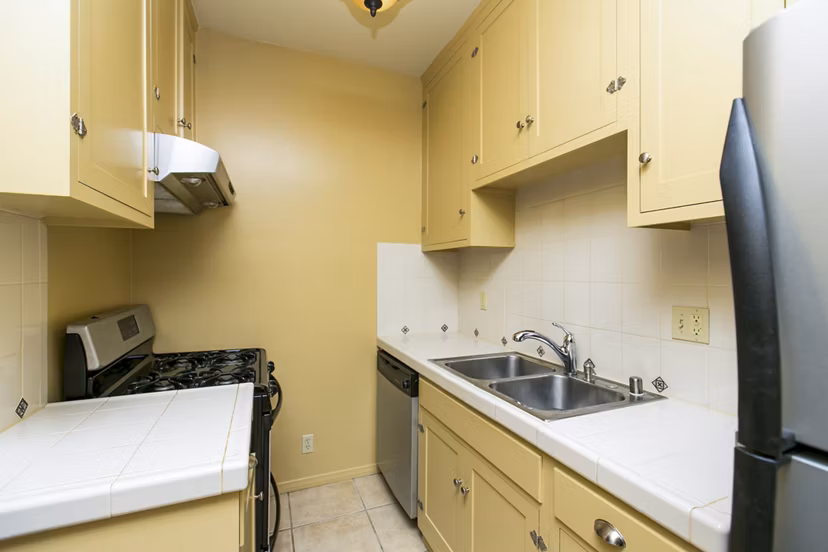 Kitchen area featuring modern appliances and sleek cabinetry in Delta Apartments