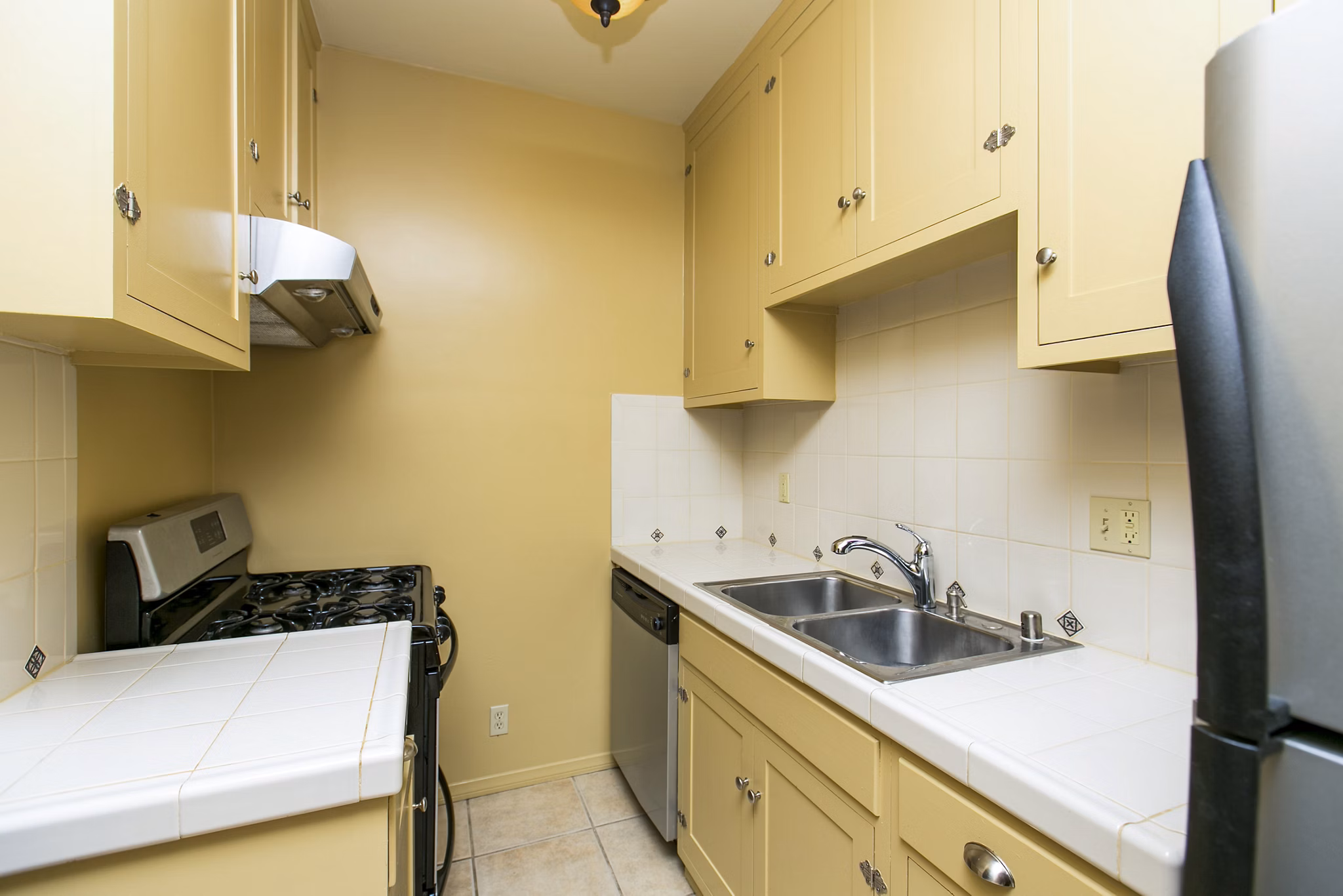 Kitchen area featuring modern appliances and sleek cabinetry in Delta Apartments