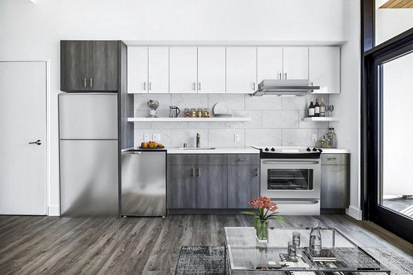 Modern kitchen featuring stainless steel appliances and granite countertops at Edendale Crossing Apartments