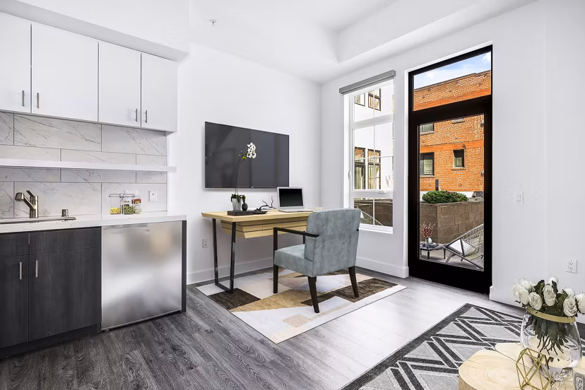 Studio home office with modern kitchen at Edendale Crossing Apartments featuring sleek countertops and stainless steel appliances