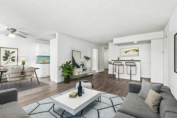 Spacious living room with modern decor and large windows at The Fulton Apartments