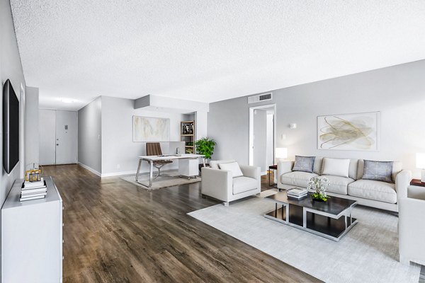 Elegant living room with contemporary decor and ample natural light at The Fulton Apartments