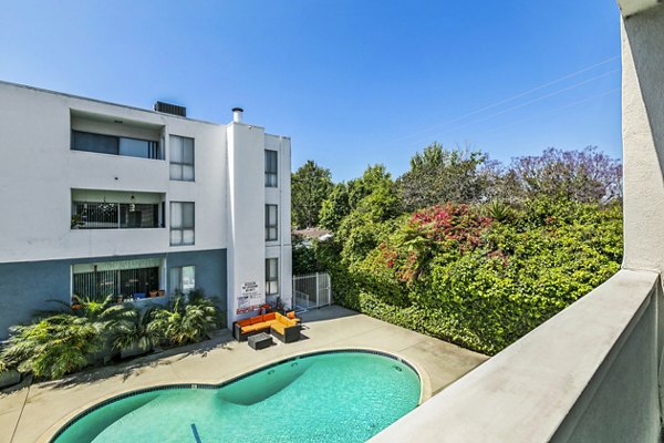 Patio/balcony view overlooking modern pool at The Fulton Apartments, offering luxurious outdoor living spaces