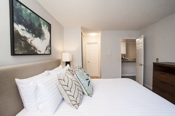 Bedroom with modern decor and plush bedding at Milano Apartments in luxury Greystar community