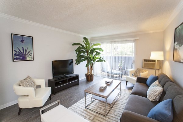 Spacious living room with modern decor and natural light at Milano Apartments