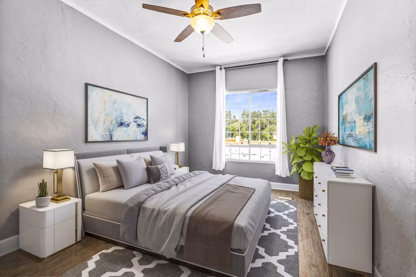 Cozy bedroom featuring plush bedding and natural light at North Kingsley Apartments