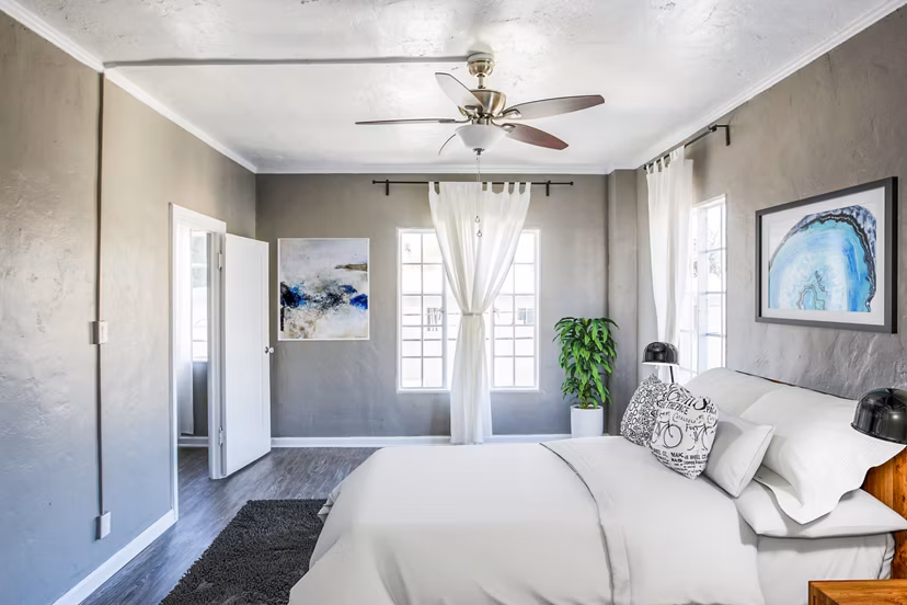 Cozy bedroom with modern furnishings at North Kingsley Apartments, a Greystar luxury property