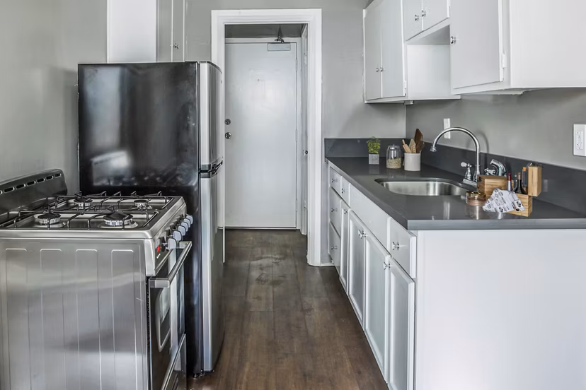Kitchen with modern appliances and marble countertops in North Kingsley Apartments