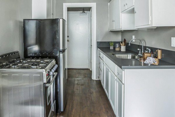 Kitchen with modern appliances and marble countertops in North Kingsley Apartments