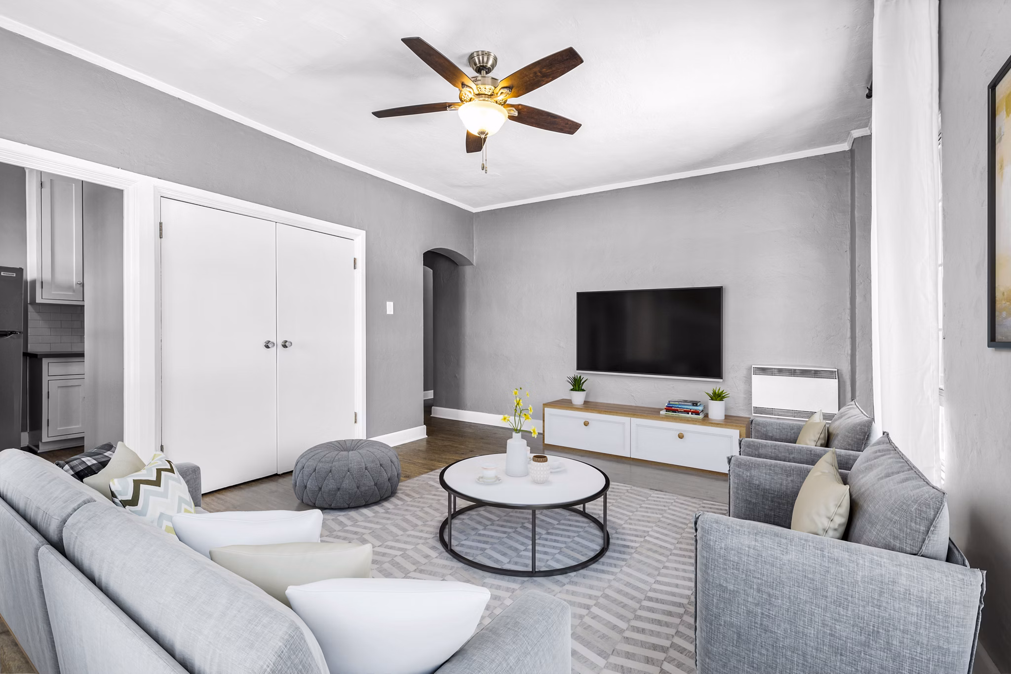 Spacious living room with modern decor and large windows at North Kingsley Apartments, offering comfort and style for luxury living
