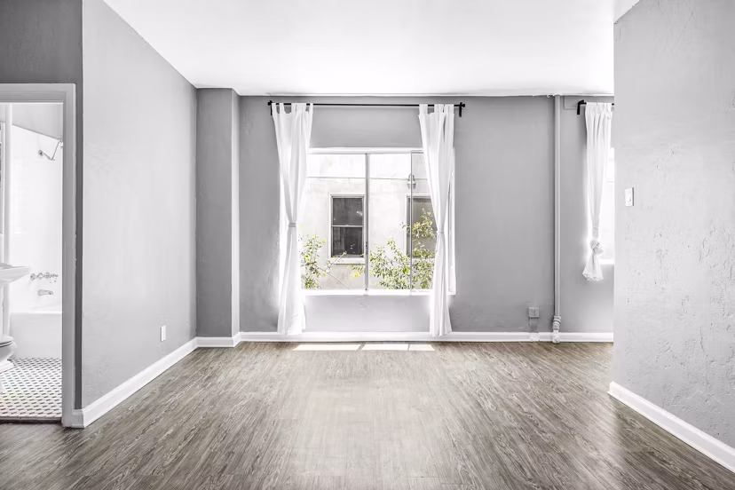 Cozy living room with modern decor and large windows at North Kingsley Apartments