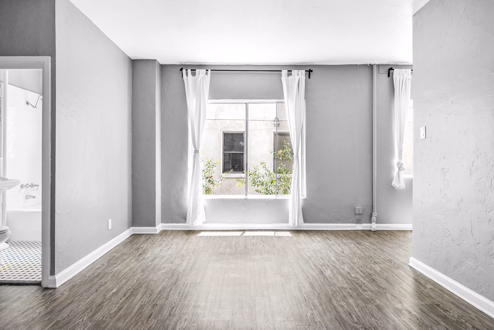 Cozy living room with modern decor and large windows at North Kingsley Apartments