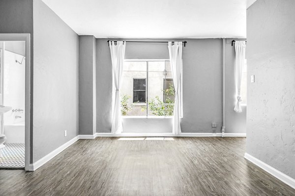 Cozy living room with modern decor and large windows at North Kingsley Apartments