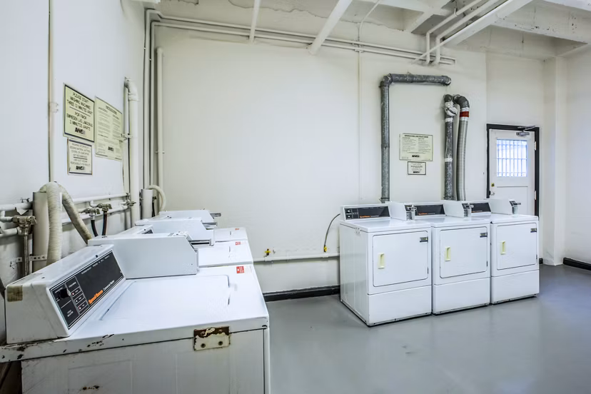 Modern laundry facility at North Kingsley Apartments with energy-efficient machines and folding stations