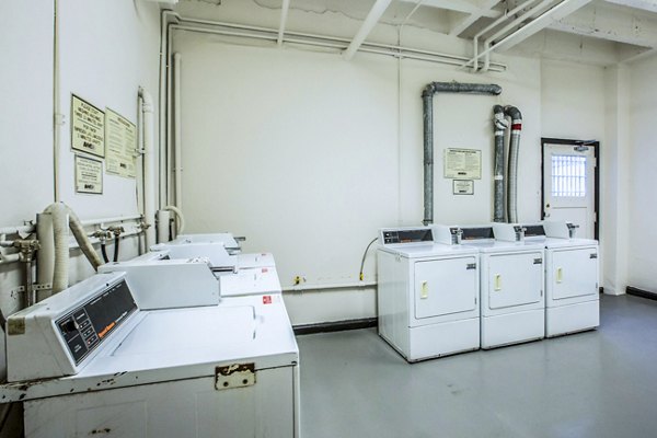 Modern laundry facility at North Kingsley Apartments with energy-efficient machines and folding stations