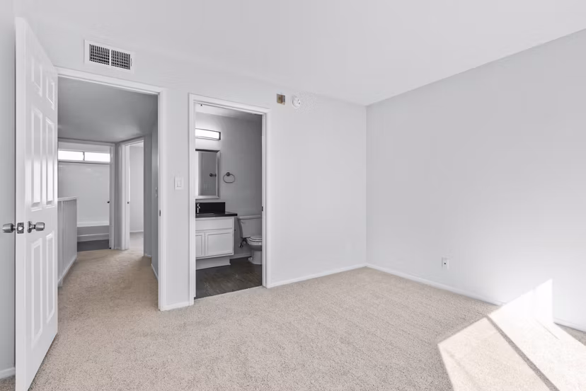 Nova Townhomes Apartments: Modern bedroom with large windows and stylish decor in a luxury apartment community