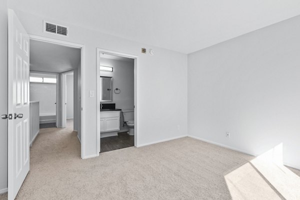 Nova Townhomes Apartments: Modern bedroom with large windows and stylish decor in a luxury apartment community