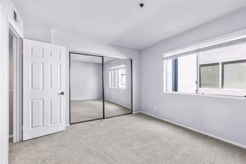 Nova Townhomes: Cozy bedroom with contemporary design and ample natural light in luxury apartments