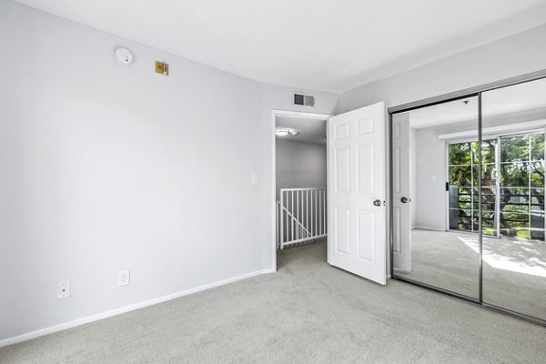 Cozy bedroom with modern furnishings at Nova Townhomes Apartments, luxury living by Greystar