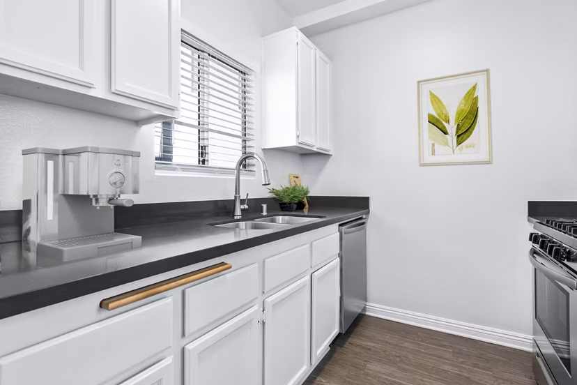 Modern kitchen with stainless steel appliances at Nova Townhomes Apartments ÎµÎ¾hibiting spacious layout and sleek design