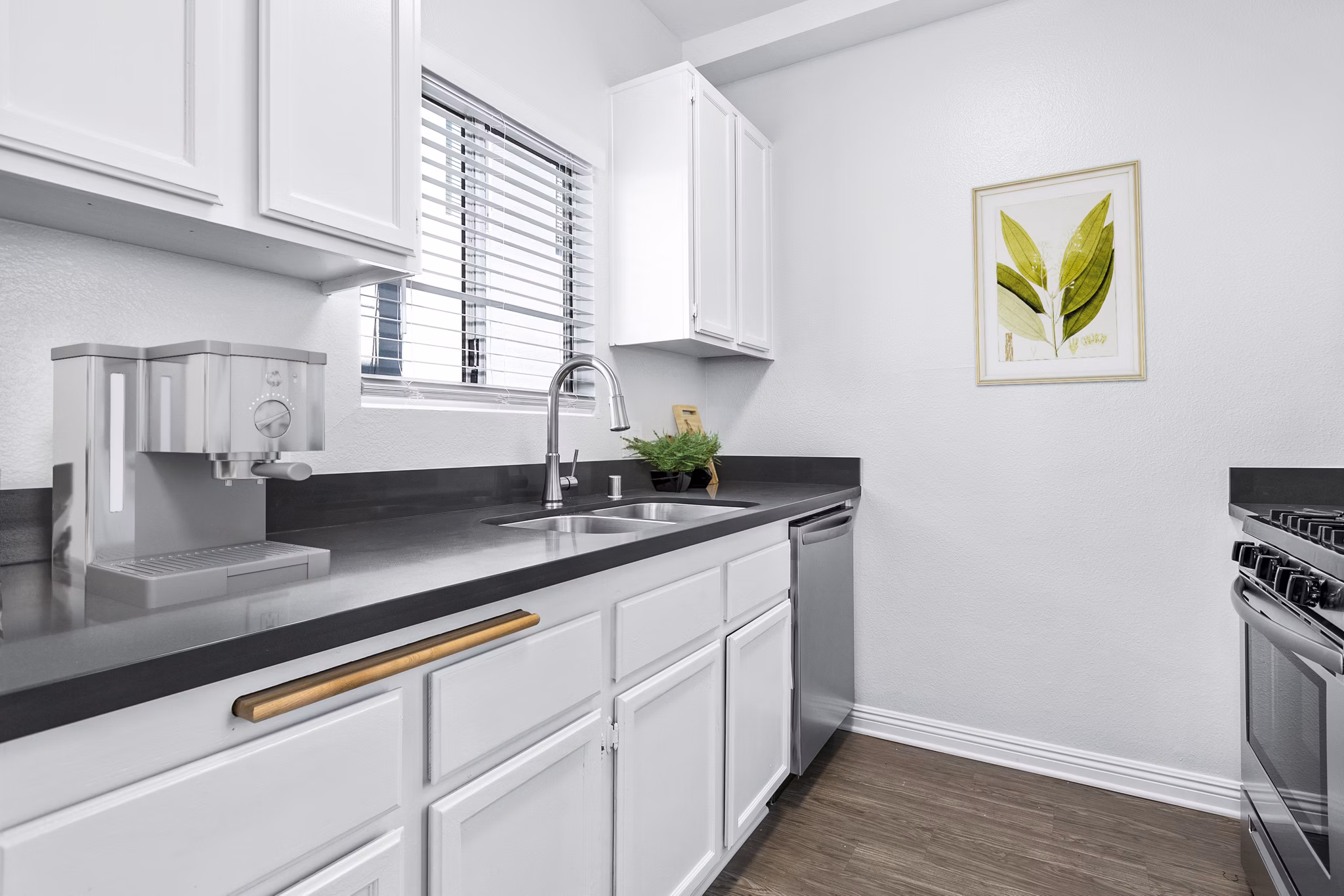 Modern kitchen with stainless steel appliances at Nova Townhomes Apartments ÎµÎ¾hibiting spacious layout and sleek design