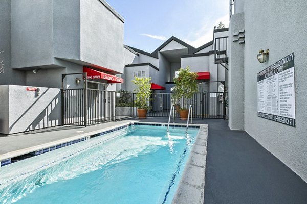 Relaxing outdoor pool with sundeck at Nova Townhomes Apartments, offering luxury living in a vibrant community setting