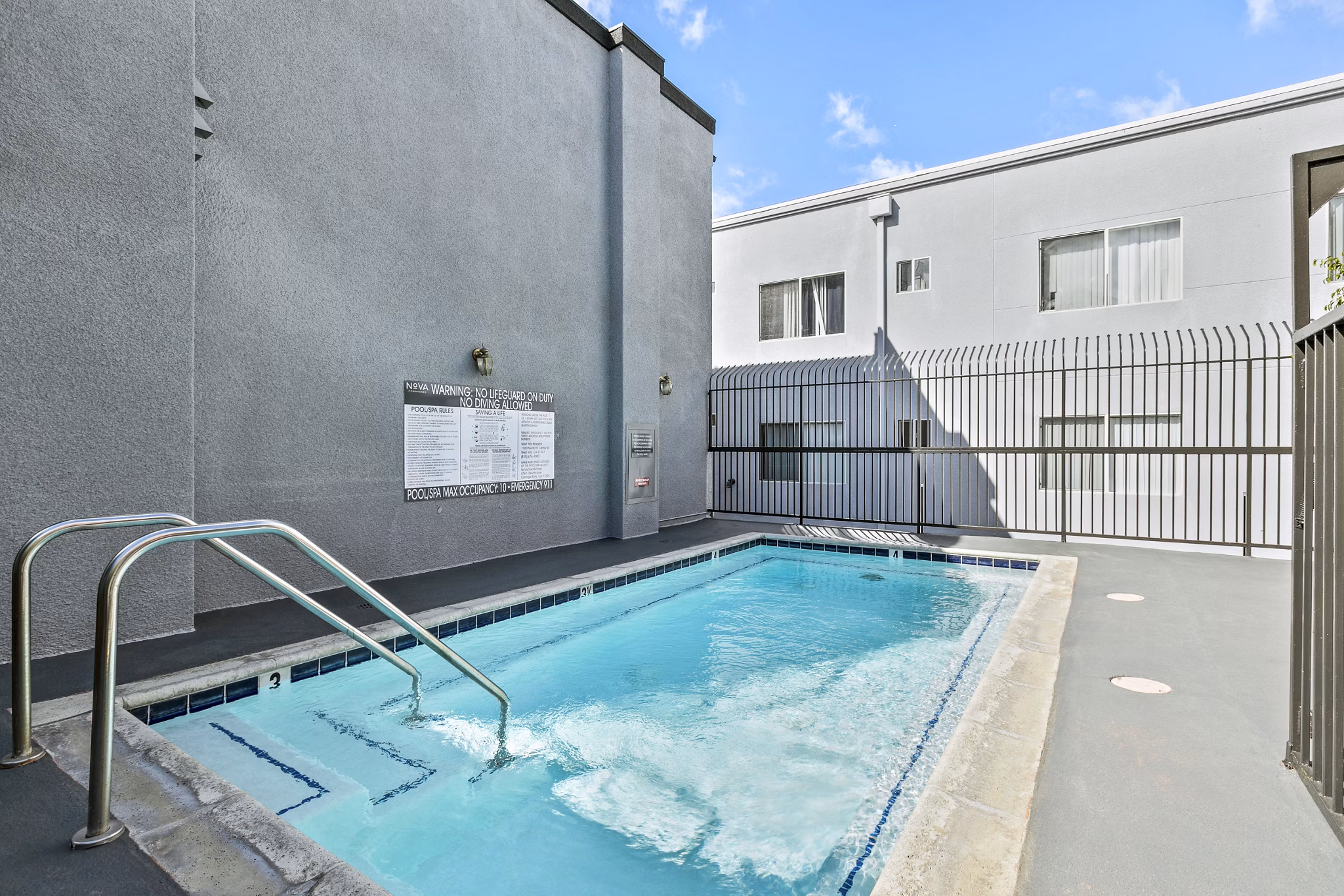 Nova Townhomes Apartments: Expansive pool area with modern lounge seating for relaxation and recreation