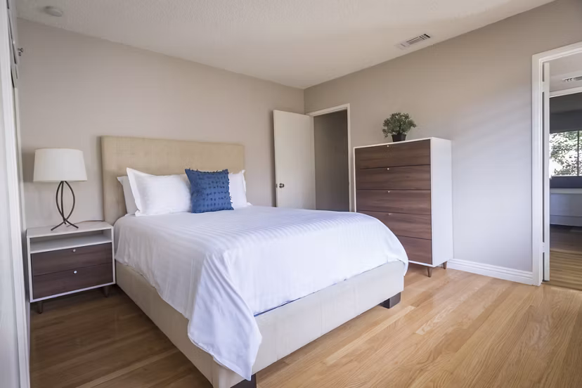Bedroom with modern decor and plush bedding at Orange Grove Circle Apartments