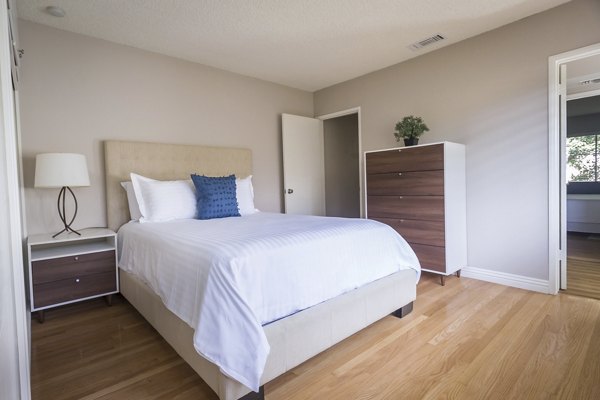 Bedroom with modern decor and plush bedding at Orange Grove Circle Apartments