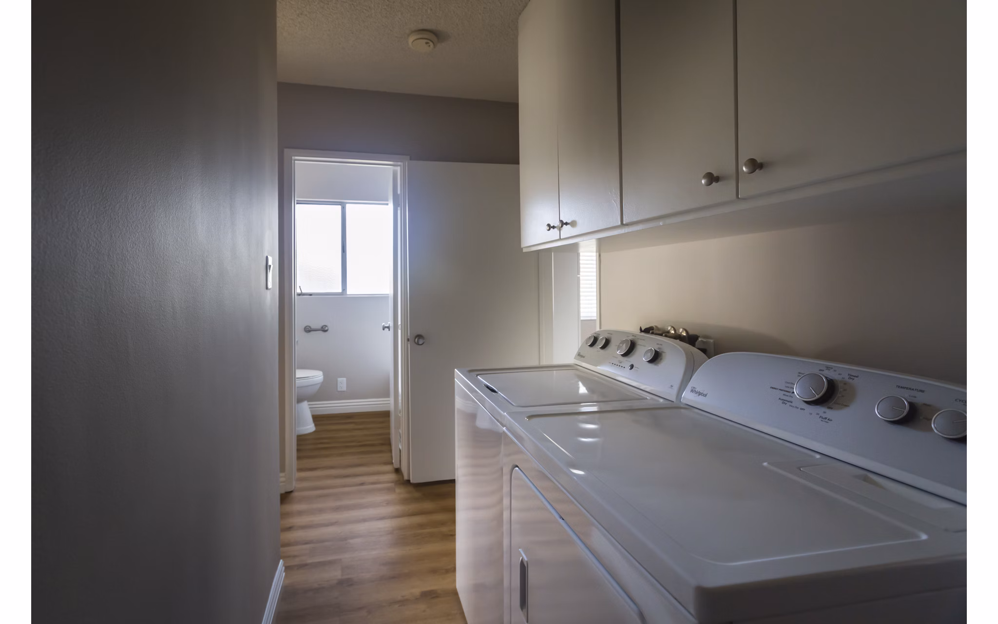 Modern laundry room with energy-efficient machines at Orange Grove Circle Apartments