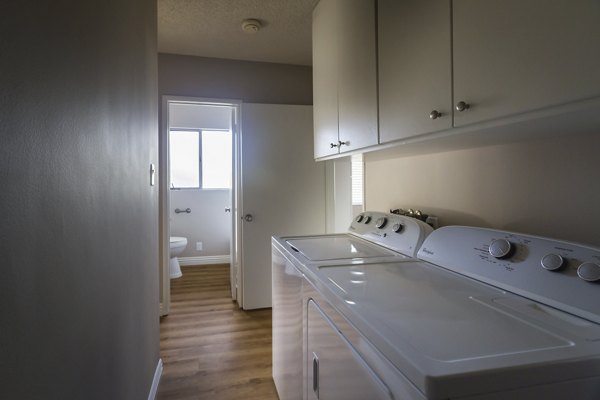 Modern laundry room with energy-efficient machines at Orange Grove Circle Apartments