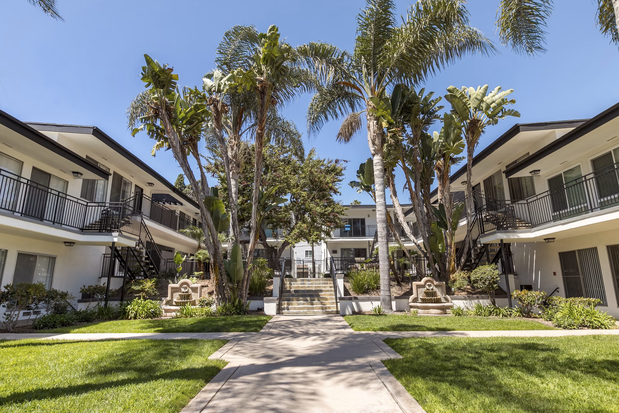 Courtyard with garden and seating area at Pacific Rose Apartments, highlighting serene outdoor spaces for relaxation and leisure