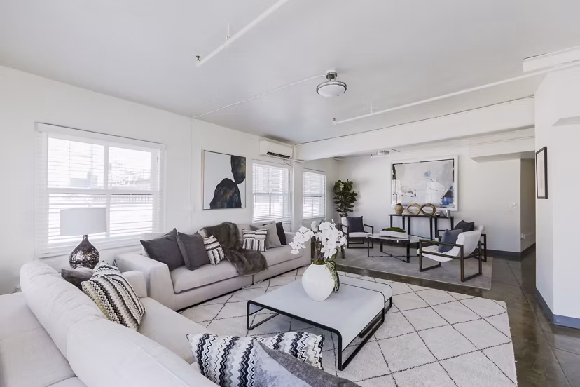Open-concept living room with elegant decor and large windows in San Fernando Building Apartments