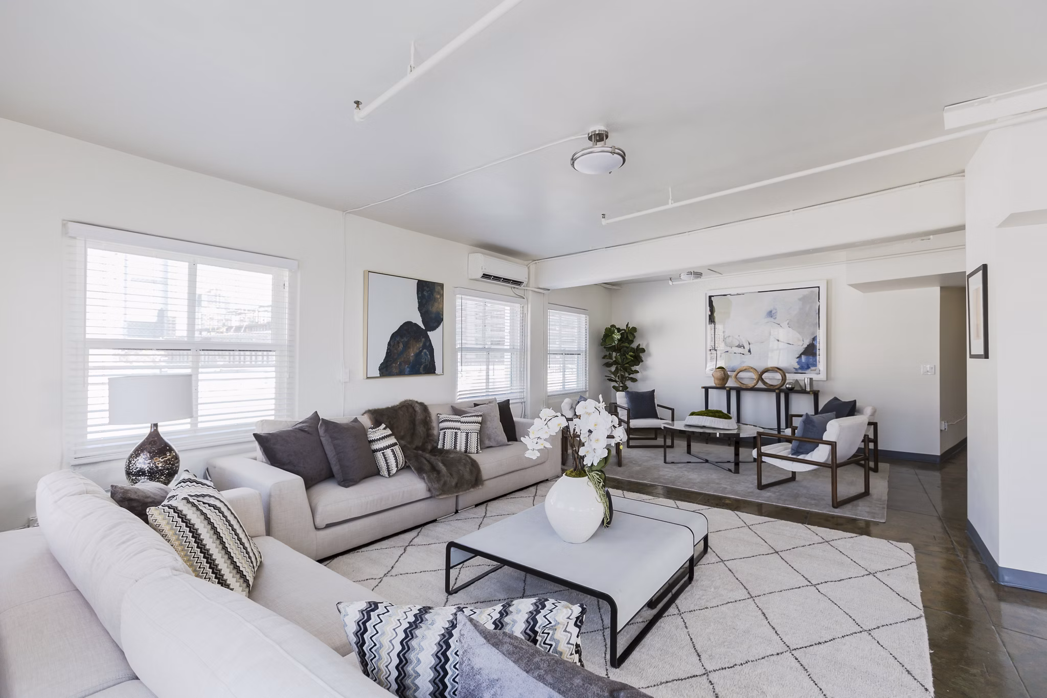 Open-concept living room with elegant decor and large windows in San Fernando Building Apartments