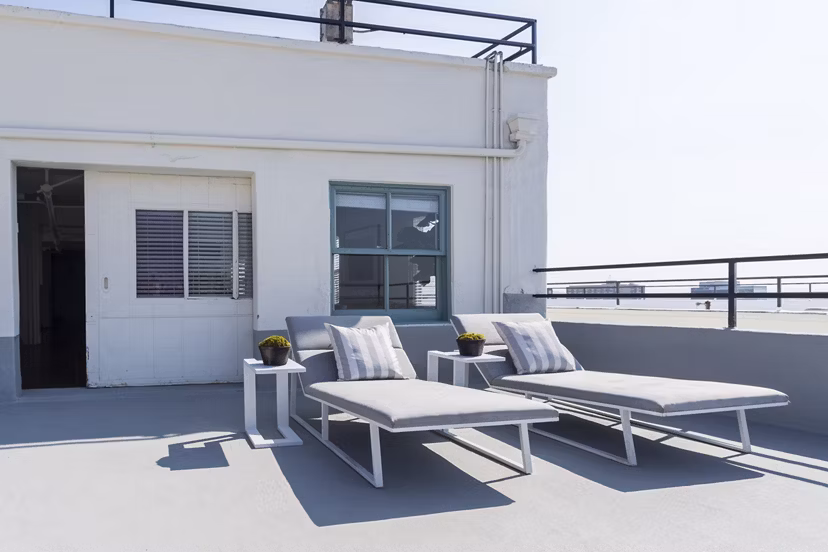 Rooftop deck with ample seating and city views at San Fernando Building Apartments
