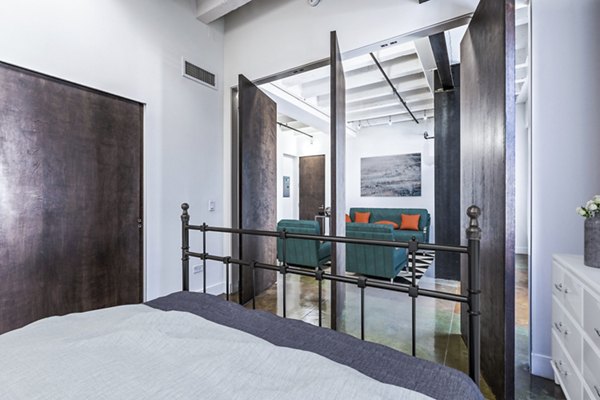 Bedroom featuring minimalist design with large windows at South Park Lofts Apartments