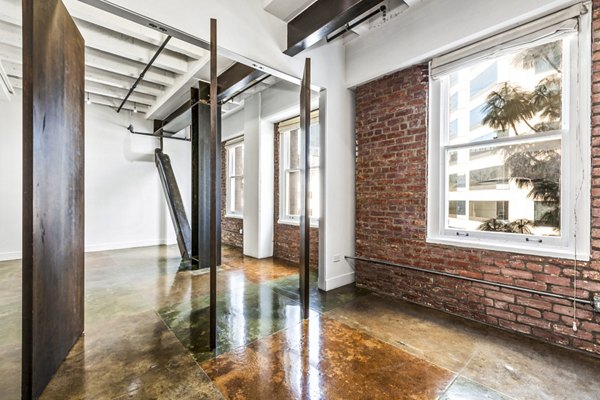 Bedroom with modern furniture and large windows at South Park Lofts Apartments, offering luxury living in a vibrant urban environment