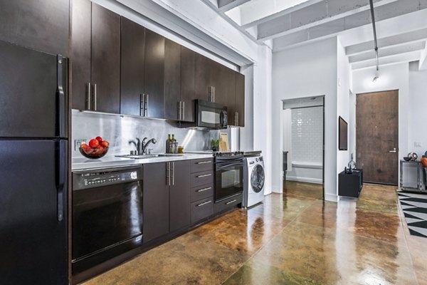 Modern kitchen with stainless steel appliances and island at South Park Lofts Apartments