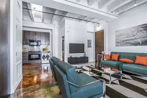 Modern living room with sleek furniture and large windows at South Park Lofts Apartments