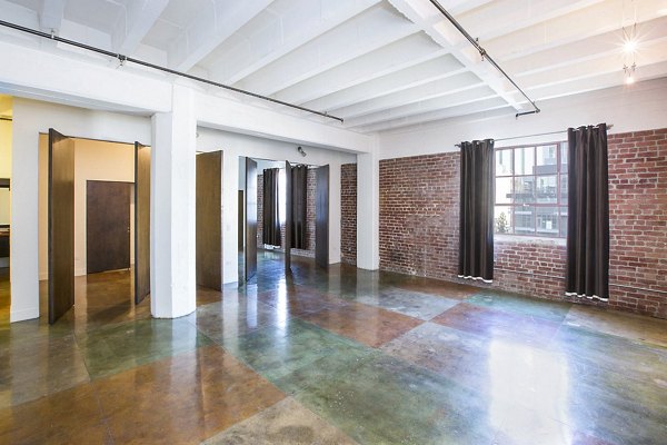 Modern living room with large windows and contemporary furniture at South Park Lofts Apartments