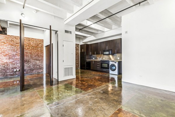 Spacious living room with modern decor and large windows at South Park Lofts Apartments