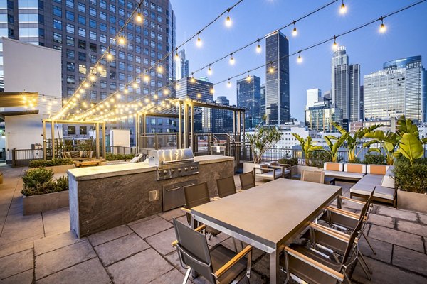 Outdoor grill area and patio at South Park Lofts Apartments featuring modern seating and greenery