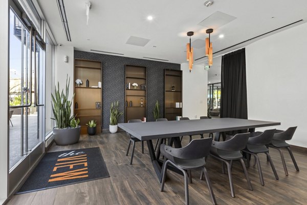 Conference room with long table, chairs, plants, and shelves at The View Apartments