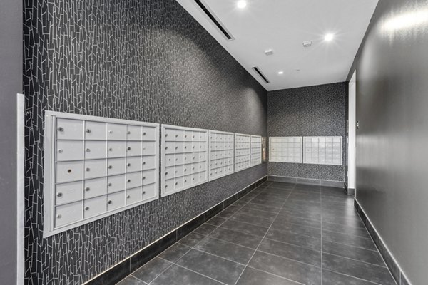 Modern mailroom with multiple mailboxes and dark tiled floor at The View Apartments