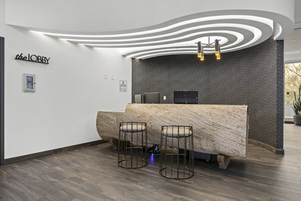 The View Apartments: Sleek lobby with curved ceiling, wooden desk, and stools in luxury setting