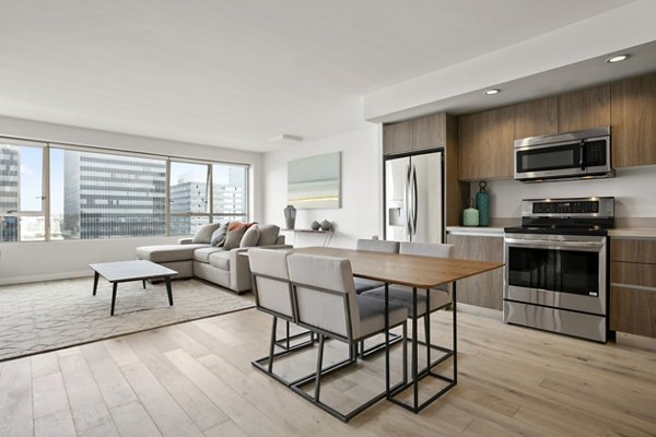 Modern open-concept apartment with kitchen, dining area, and living room at The View Apartments