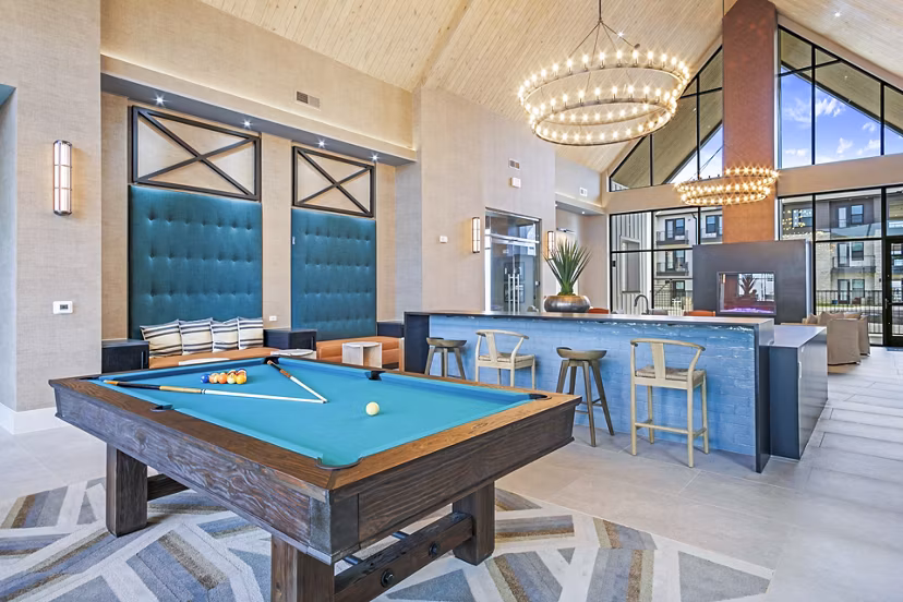 Clubhouse game room with pool table and modern seating at The Gin Mill Apartments, offering luxury living spaces