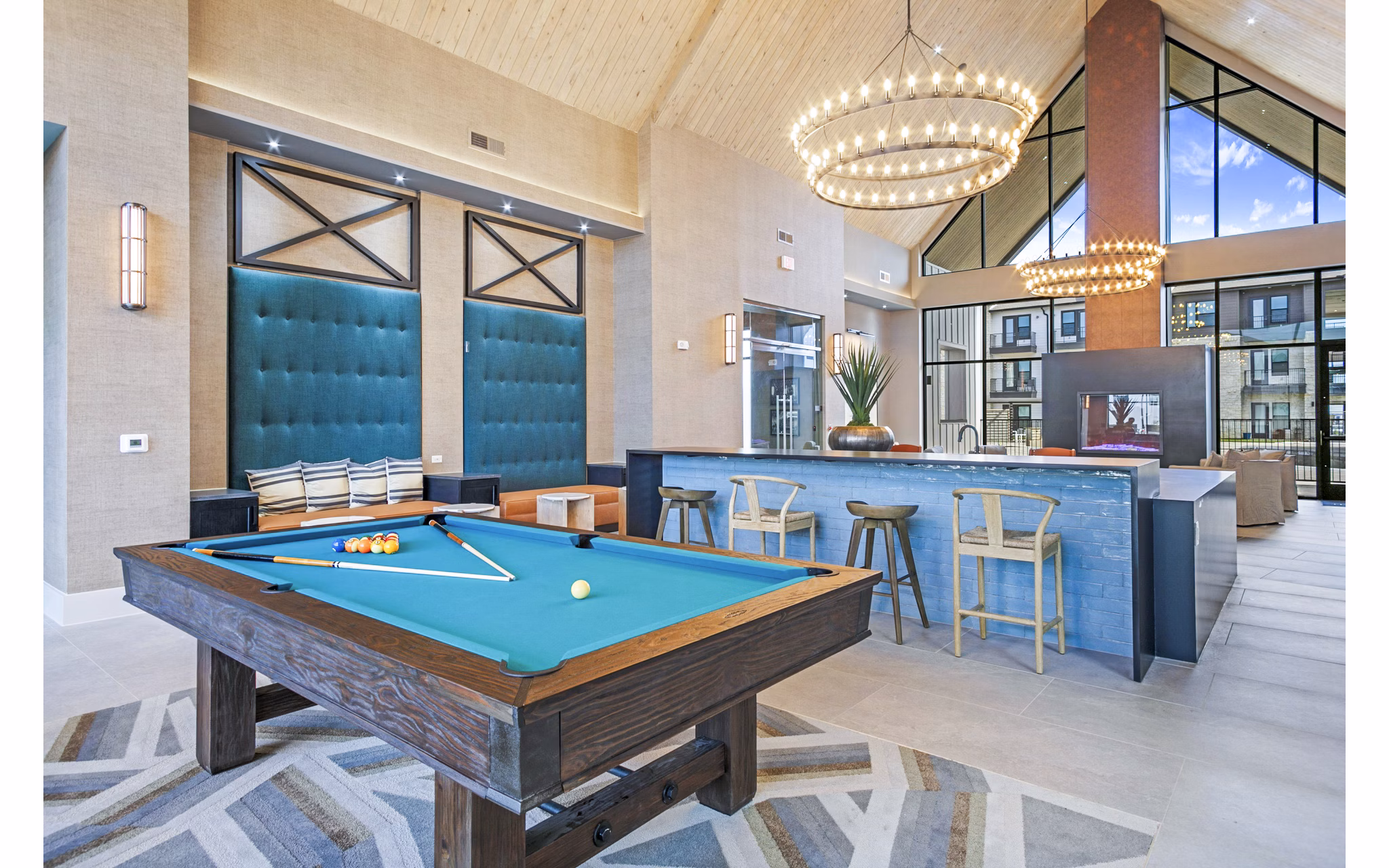 Clubhouse game room with pool table and modern seating at The Gin Mill Apartments, offering luxury living spaces