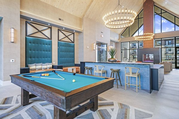Clubhouse game room with pool table and modern seating at The Gin Mill Apartments, offering luxury living spaces