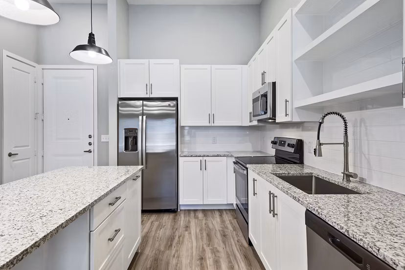 Modern kitchen featuring stainless steel appliances and sleek countertops at The Gin Mill Apartments